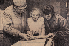 press cutting of 3 people viewing an exhibit