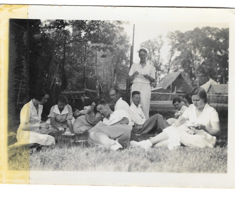 group of adults sitting on the grass